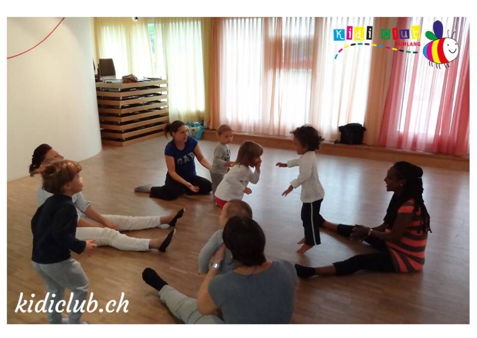 Eine Gruppe von Menschen macht in einem Raum Dehnübungen.