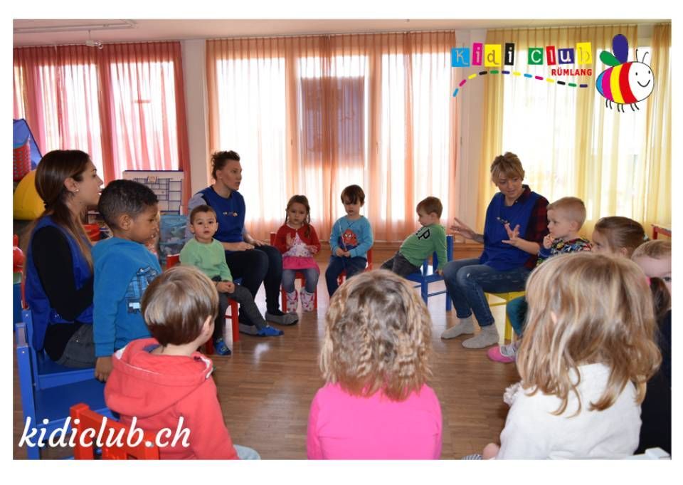 Eine Gruppe von Kindern sitzt in einem Raum im Kreis.