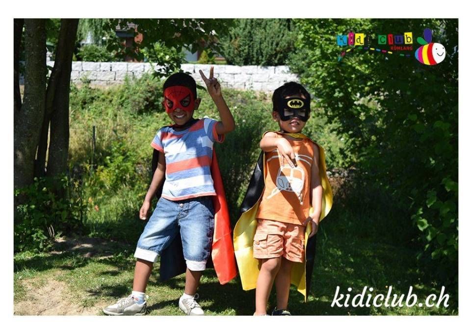 Zwei junge Jungen mit Umhängen und Masken stehen nebeneinander.