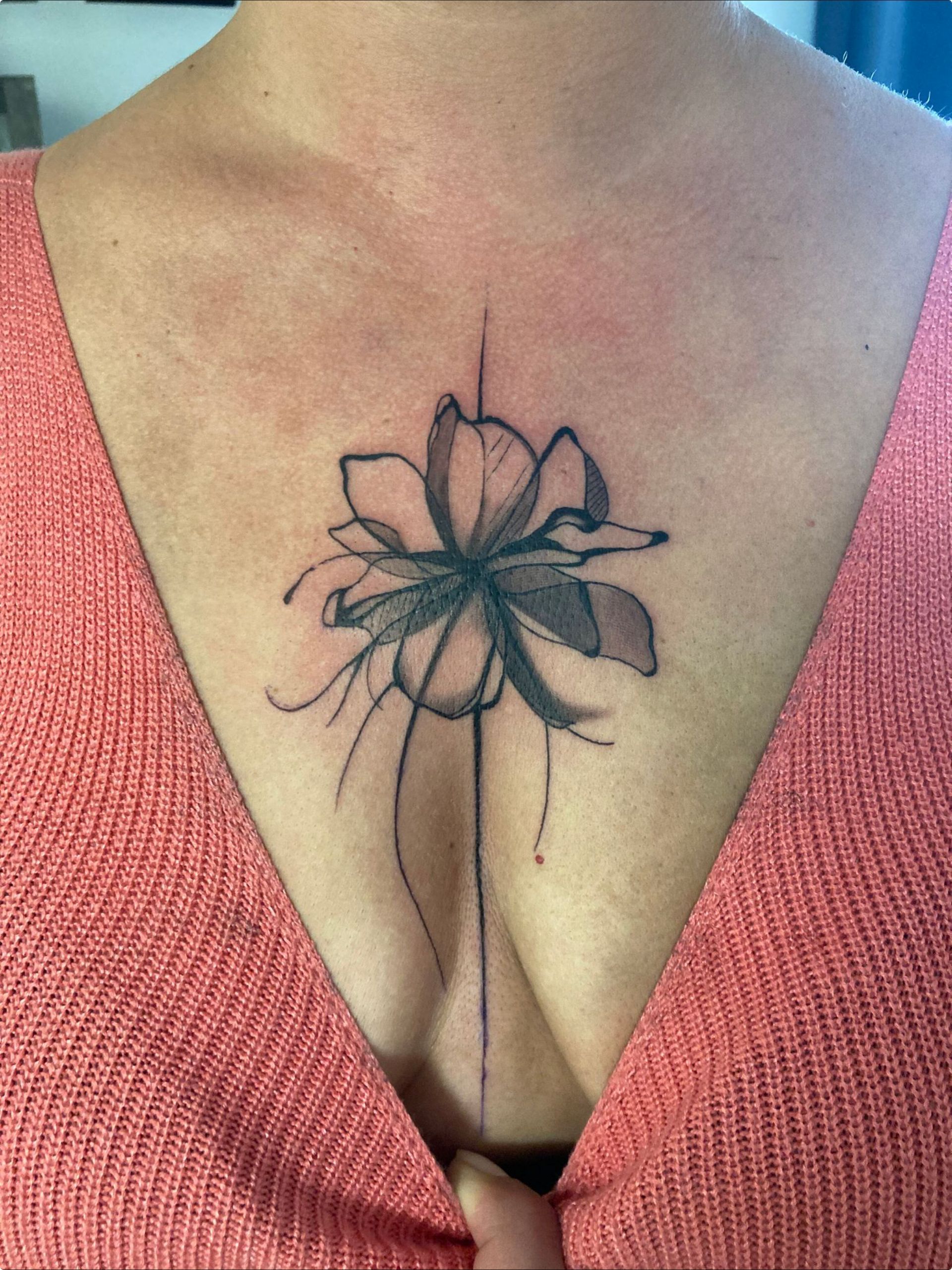 Eine Frau hat eine Blumentätowierung auf ihrer Brust.