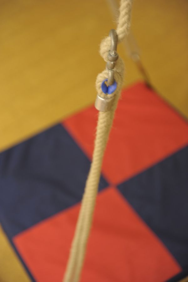 WSeil mit Verbingungshaken über einer Stofffläche mit roten und dunkelblauen Quadraten