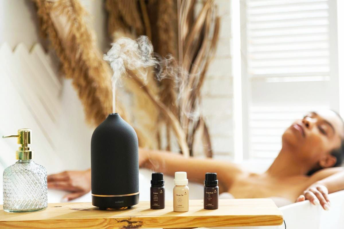 Una mujer se está bañando con aceites esenciales y un difusor.