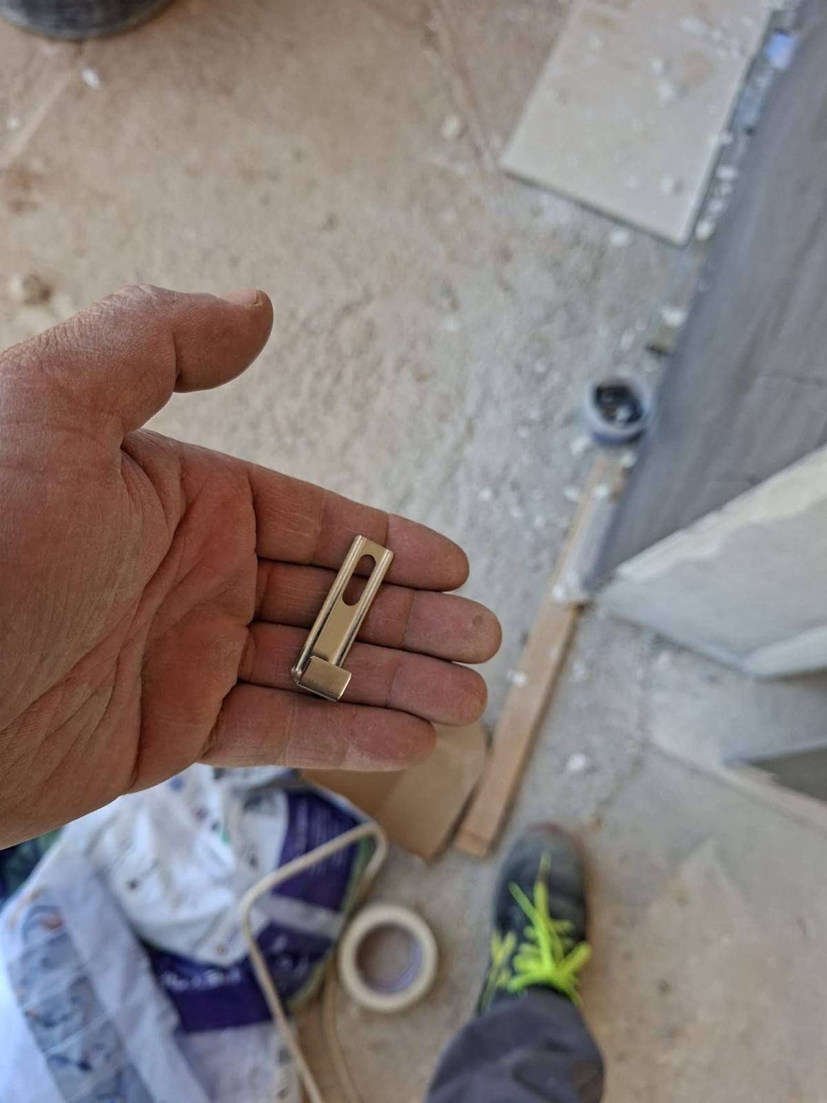 Una mano sostiene una pequeña pinza metálica sobre 