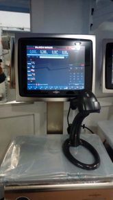 Monitor médico en un carrito de hospital con un cable negro enrollado en la base.