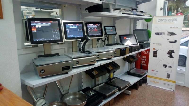 Mostrador de comida rápida con tres cajas registradoras con pantalla táctil, estantes para la preparación de alimentos y un cartel con el menú a la derecha.