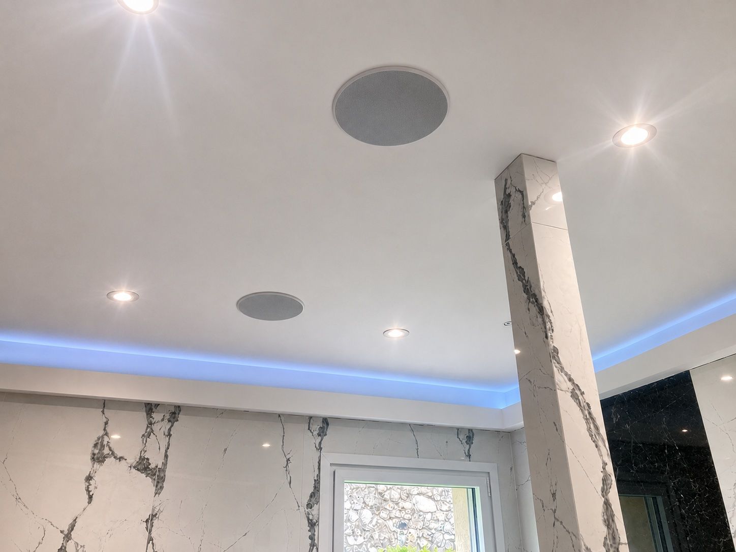 Plafond de salle de bain moderne avec spots encastrés, éclairage LED et murs à motif.