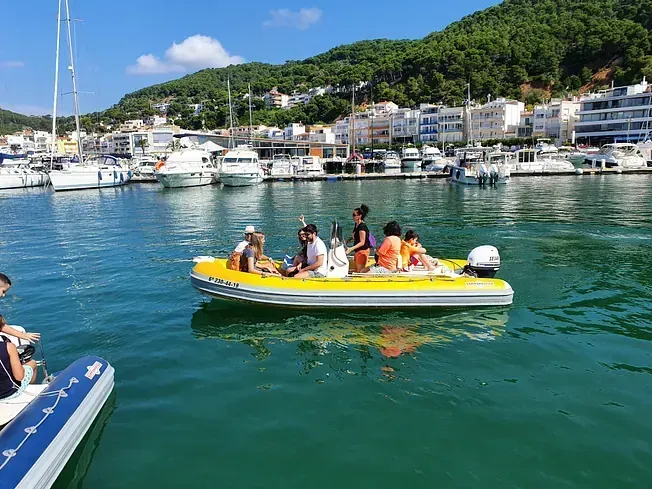 Un grupo de personas está sentada en un bote amarillo en el agua.