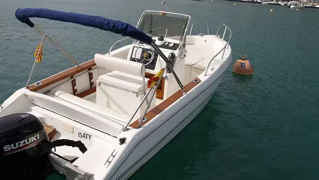 Un barco Suzuki blanco está atracado en el agua.