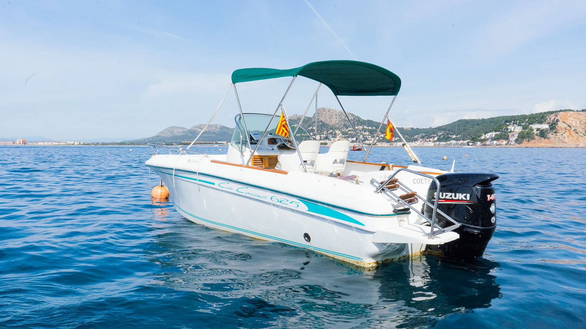 Un barco blanco con un dosel verde flota sobre un cuerpo de agua.