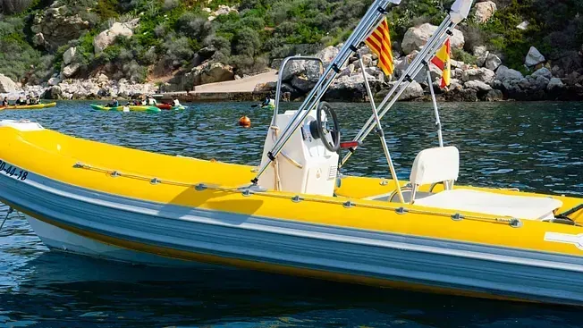 Un barco amarillo flota sobre un cuerpo de agua.