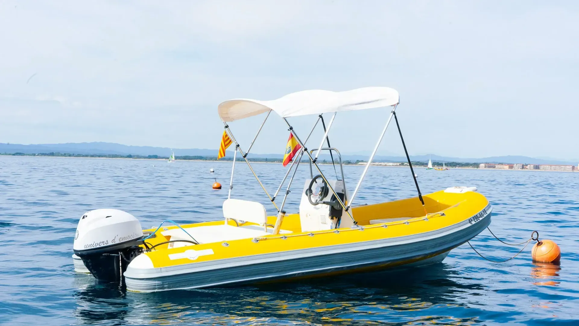 Un barco amarillo con un dosel blanco flota sobre un cuerpo de agua.