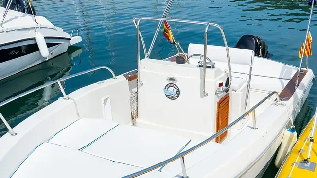 Un barco blanco está atracado en el agua al lado de un barco amarillo.