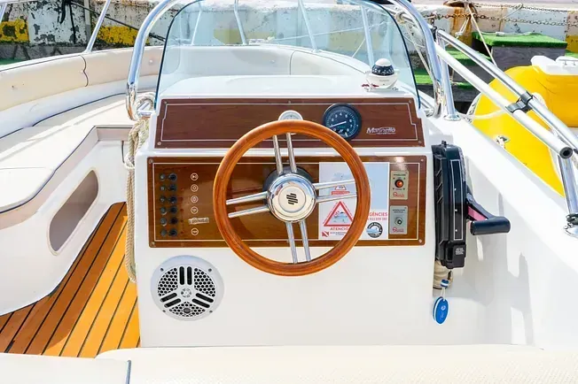 Un barco con un volante de madera y una cubierta de madera.