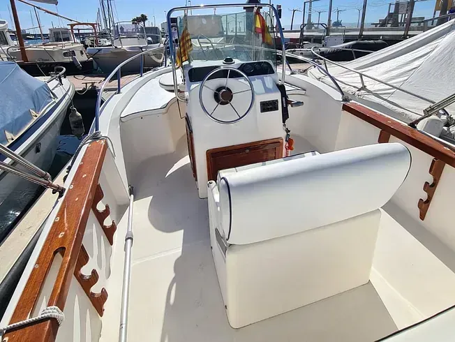 El interior de un barco con un volante y un asiento.