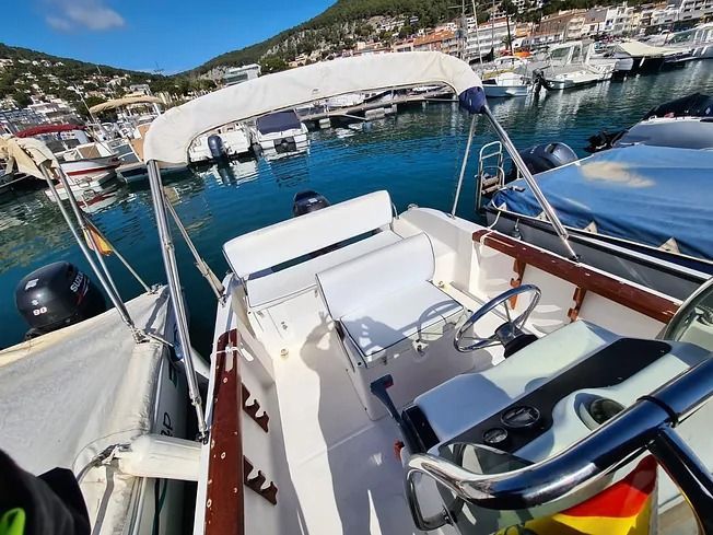 Un barco está atracado en un puerto con muchos otros barcos.