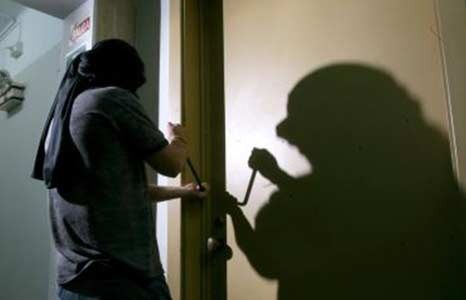 Un hombre con una máscara está intentando abrir una puerta.