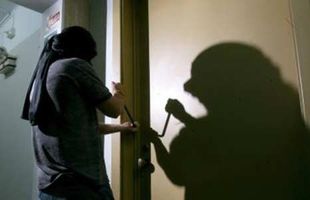 Un hombre con una máscara está intentando abrir una puerta.