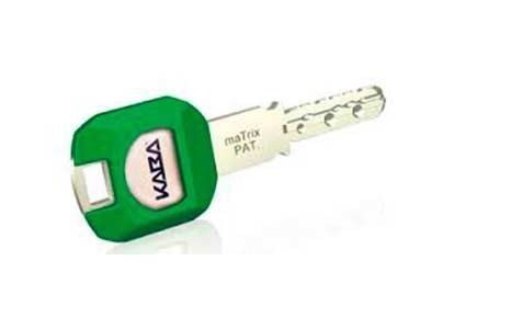 Un primer plano de una llave con una cubierta verde sobre una superficie blanca.