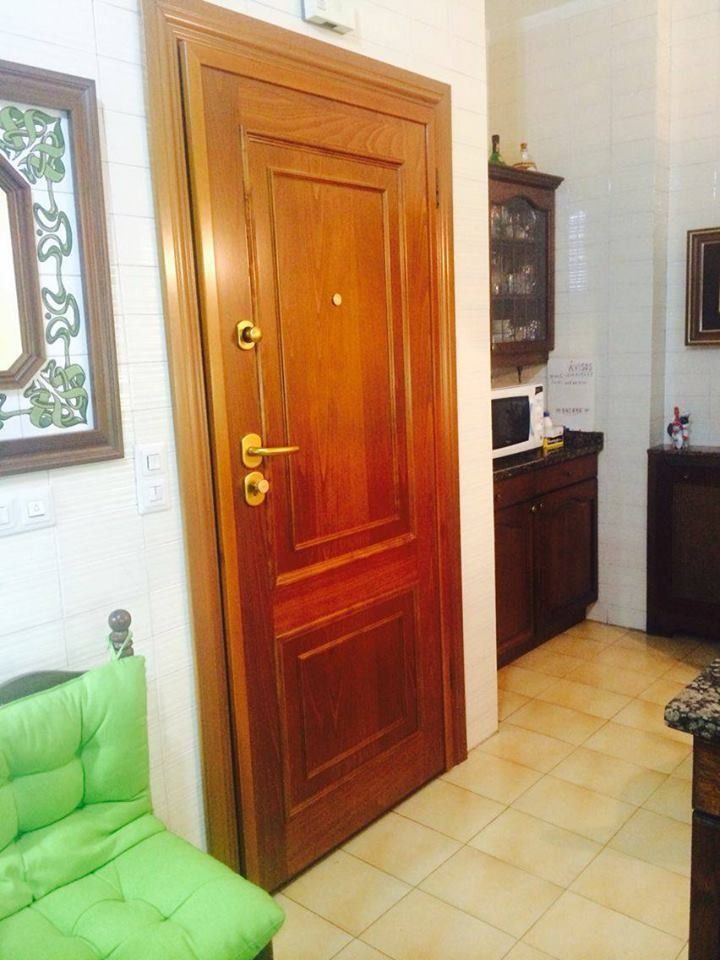 Una puerta de madera en una habitación con un sofá verde.