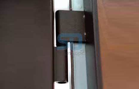 Un primer plano de una bisagra de una puerta de madera.