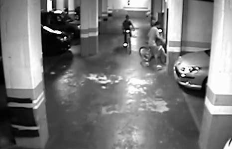 Un hombre va en bicicleta en un estacionamiento.