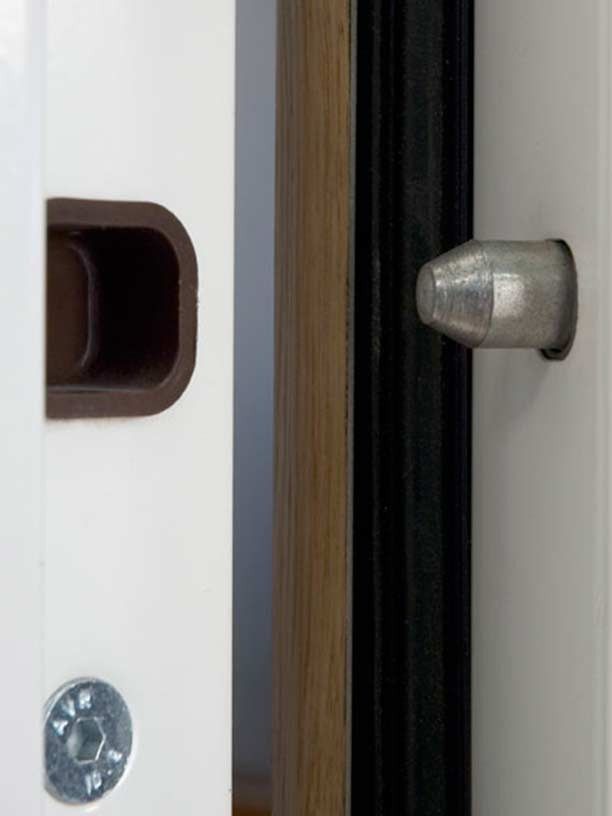 Un primer plano de una manija de puerta en una puerta blanca.