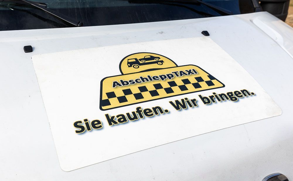 A sign on the hood of a car that says sie kaufen wir bringen