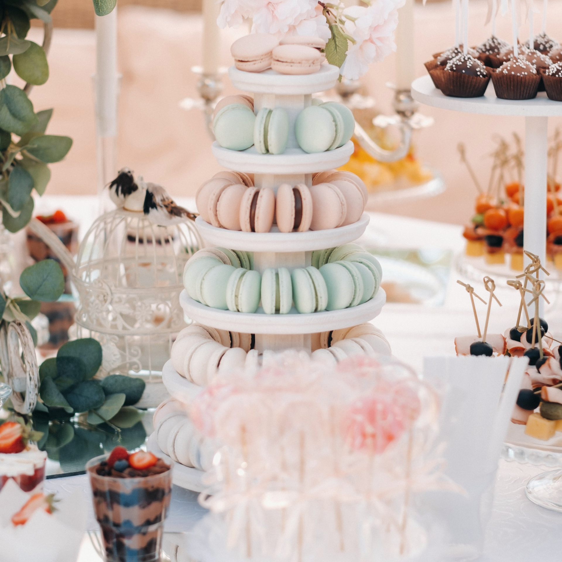 Una mesa con una torre de macarons encima.