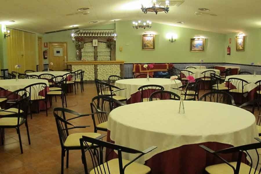 Una gran sala con mesas y sillas y un bar.