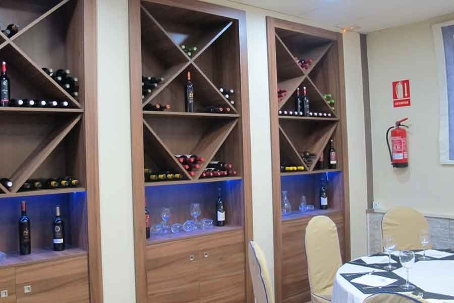 Una habitación con una mesa y sillas y un extintor en la pared.