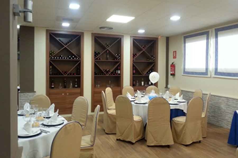 Una sala con mesas y sillas preparadas para una fiesta.