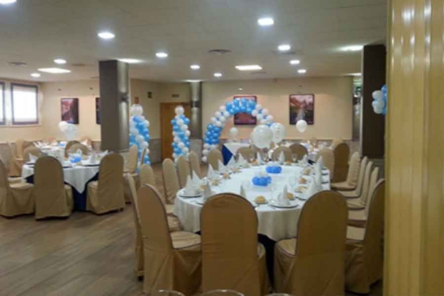 Una gran sala llena de mesas, sillas y globos.