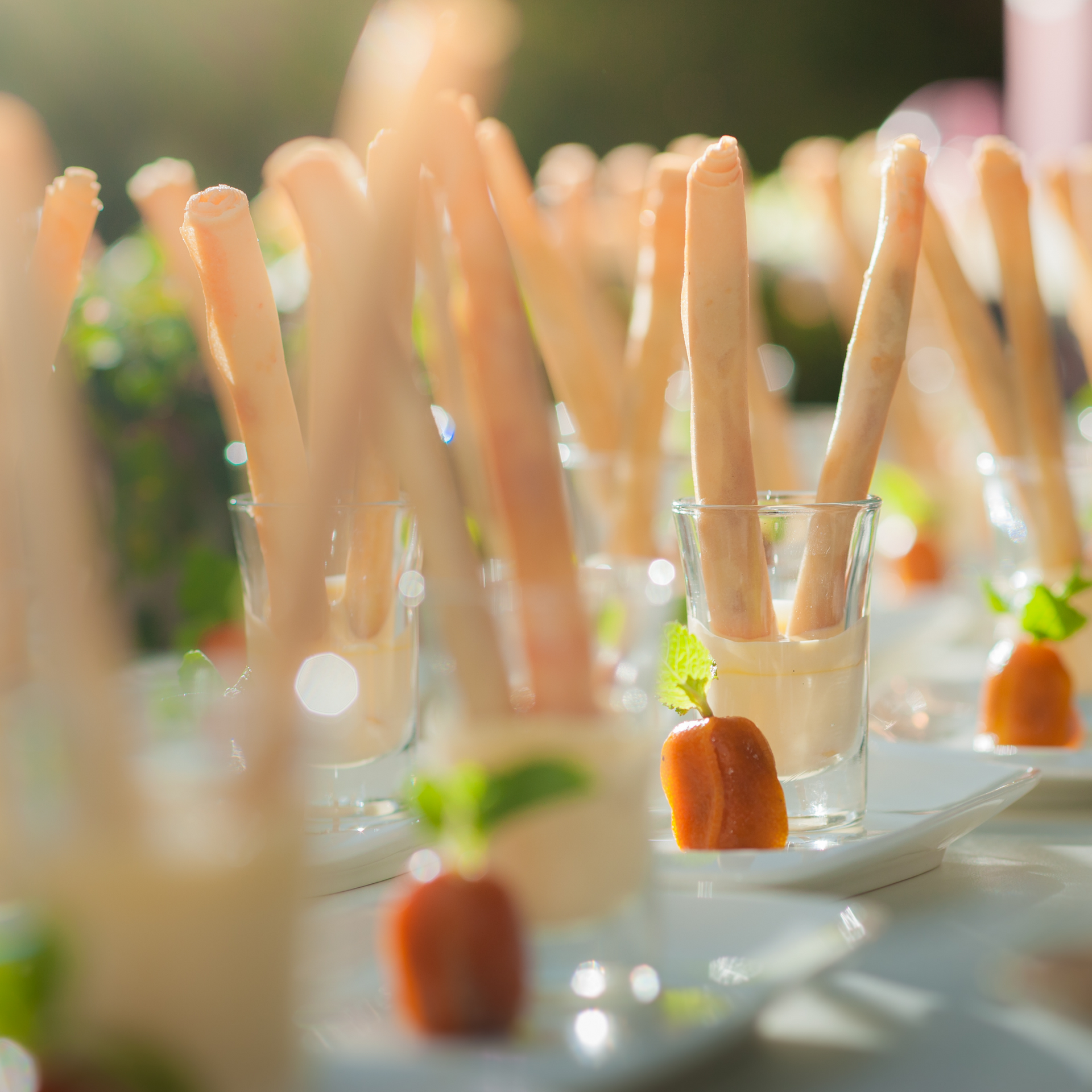 Un montón de palitos de comida en vasos, platos y una mesa.