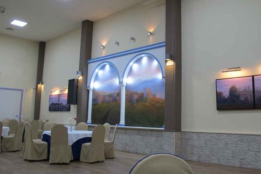 Una habitación grande con mesas y sillas y un cuadro grande en la pared.