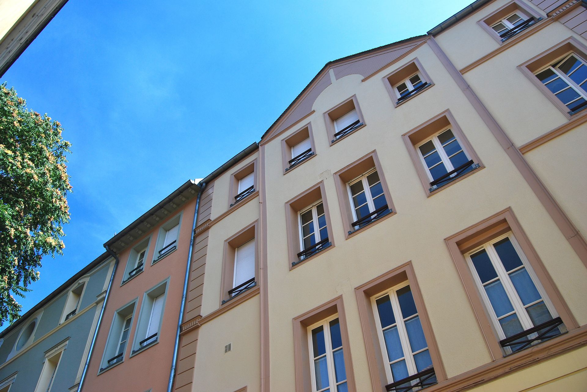 Rangée d'immeubles d'appartements colorés contre un ciel bleu clair.