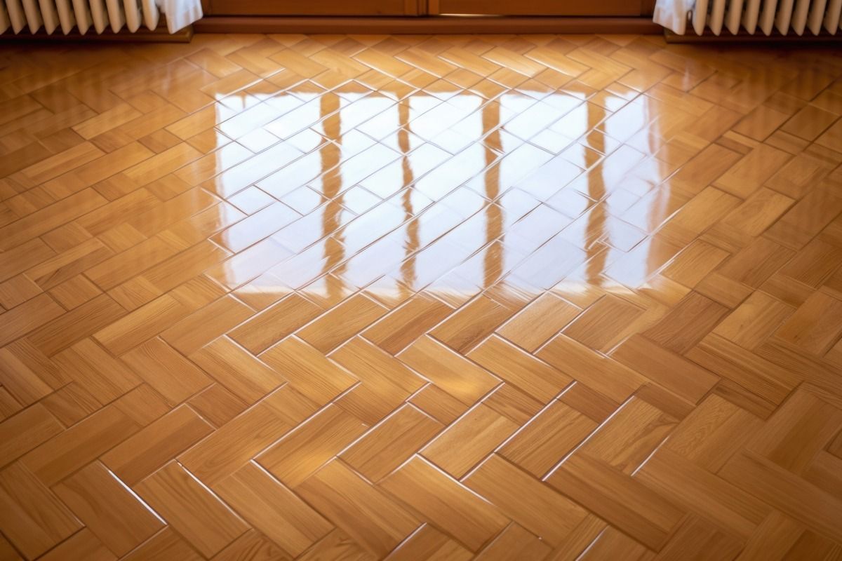 Un primer plano de un piso de madera con un patrón de espiga.