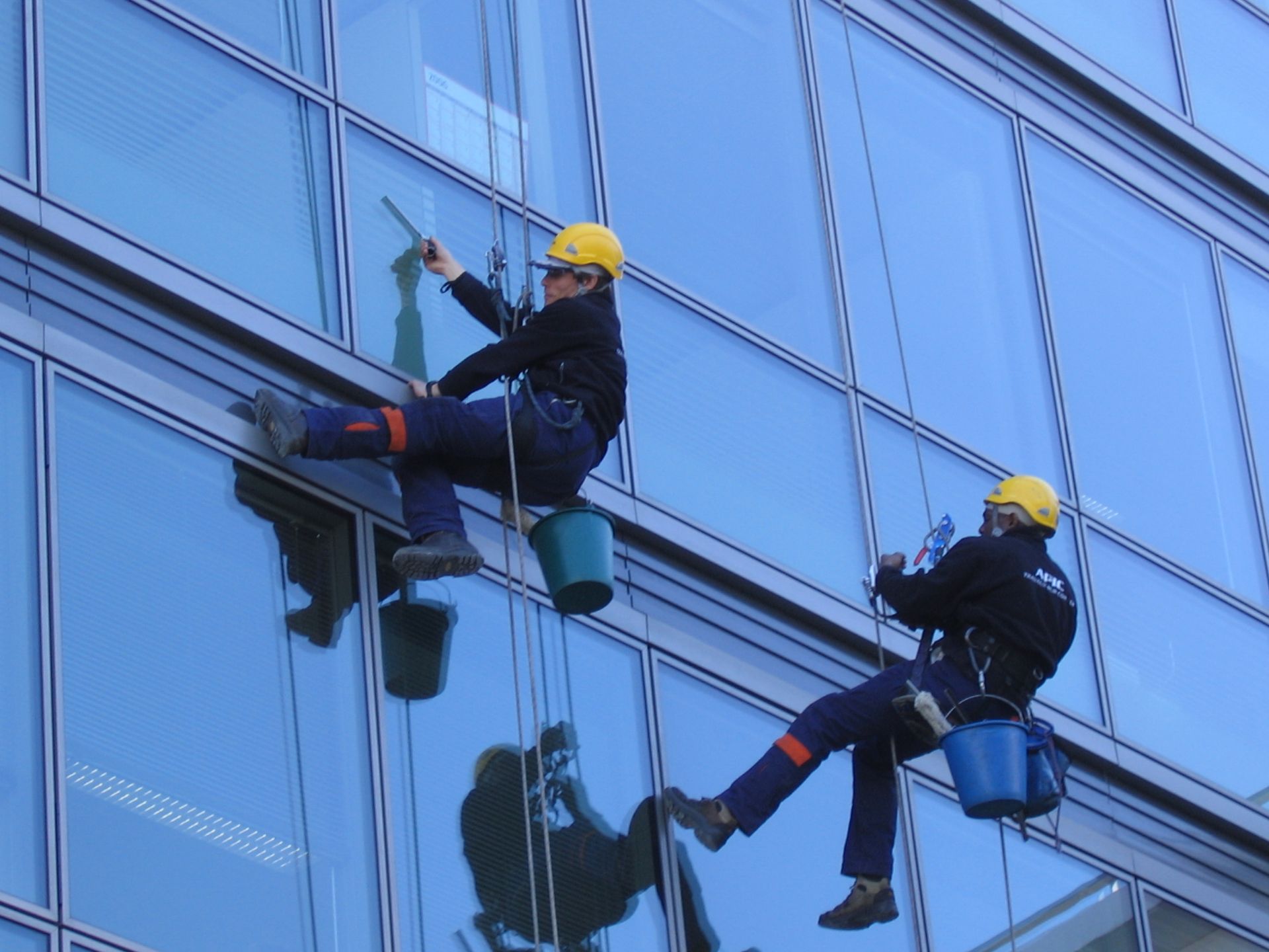 2 hommes qui nettoient les vitres en hauteur