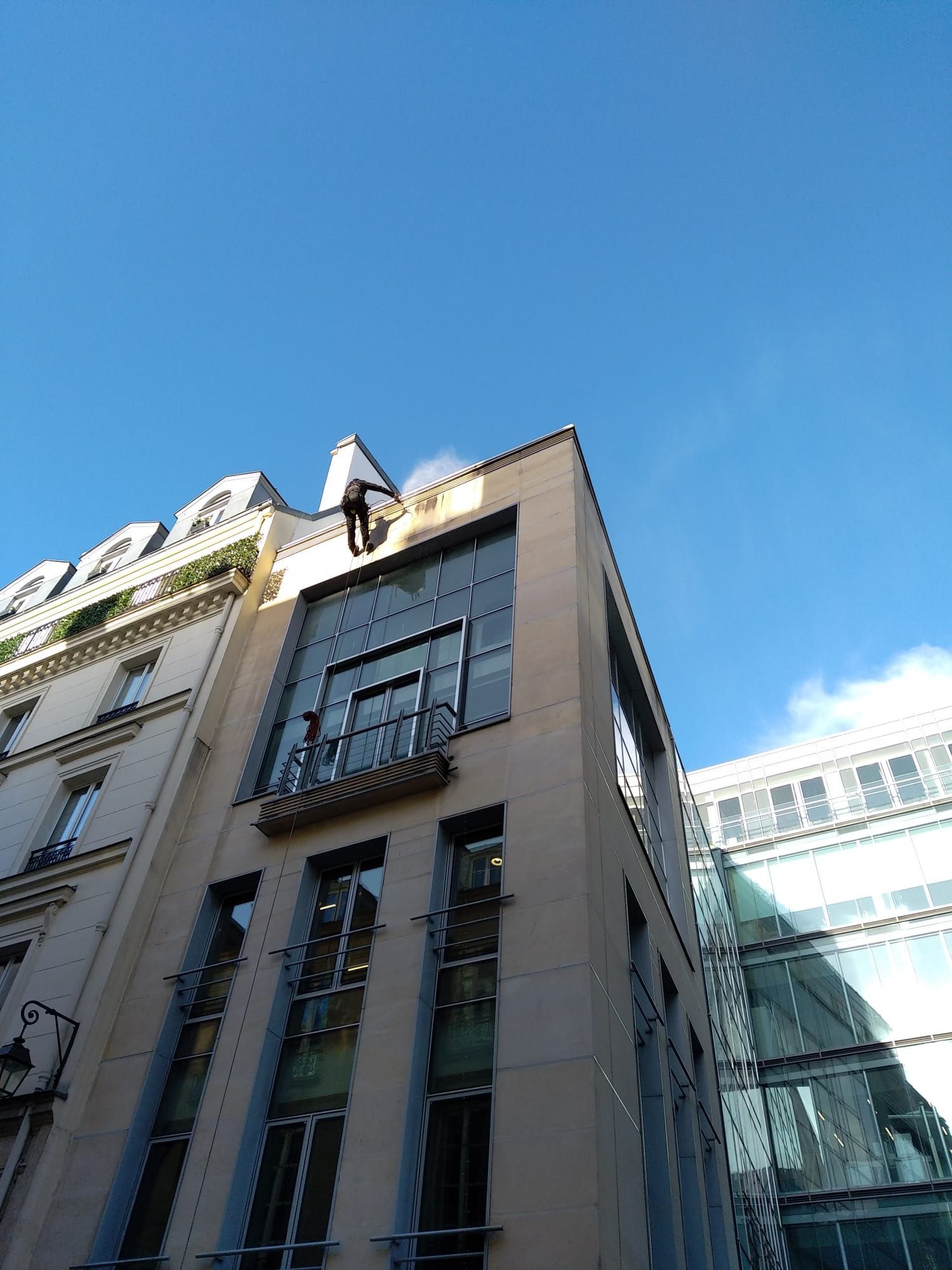 Homme sur une façade de maison en hauteur