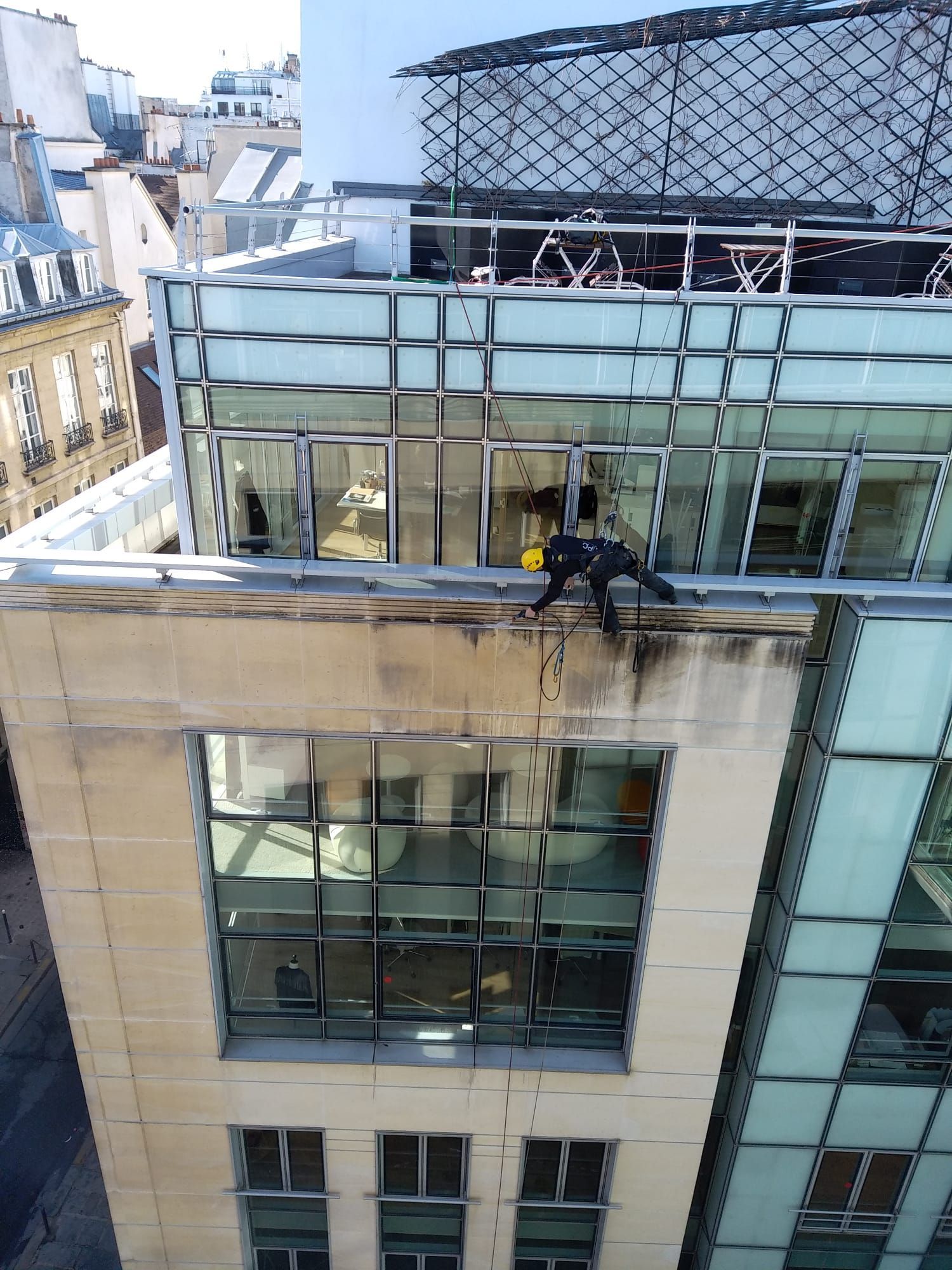 Professionnel cordiste qui nettoie une façade