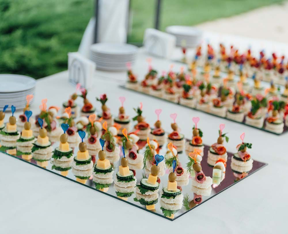 Una novia está sirviendo comida de un buffet en la recepción de su boda.