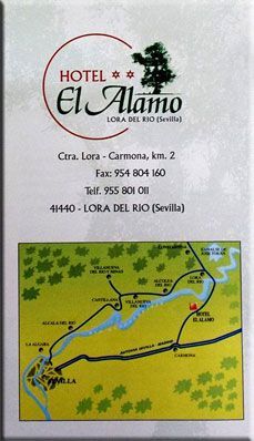Folleto del Hotel El Alamo con logotipo, dirección y mapa de Lora del Río, España.