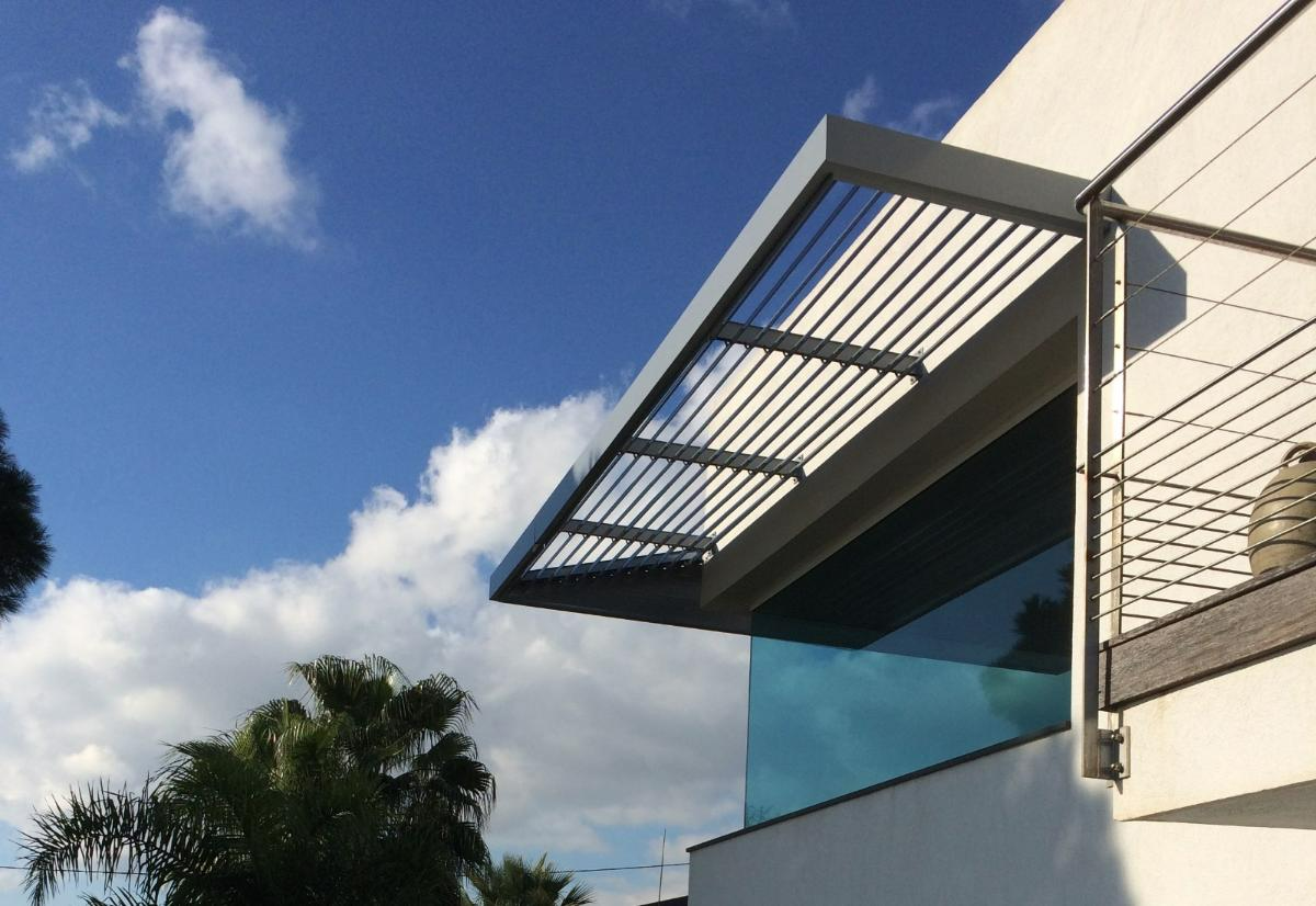 Protection solaire en métal suspendue sur une façade vitrée