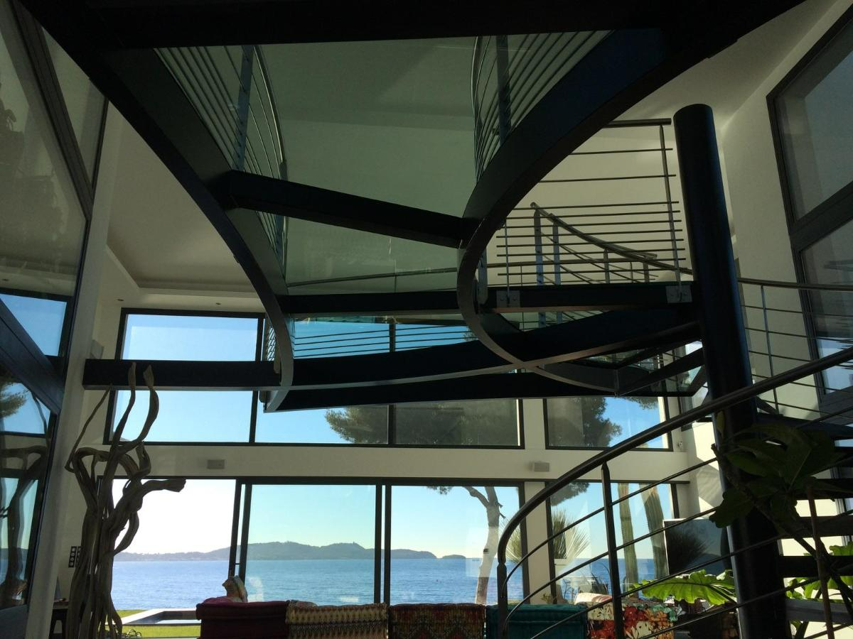 Cage d’escalier vitrée avec vue panoramique sur la mer