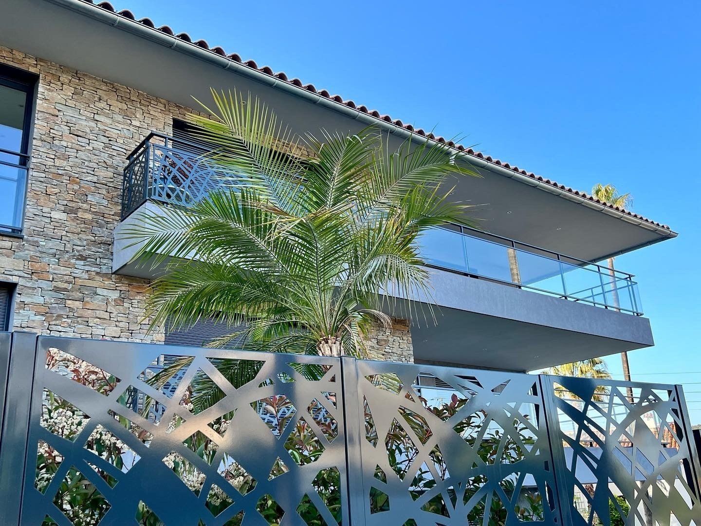 Façade et clôture ajourée d'une résidence avec balcon