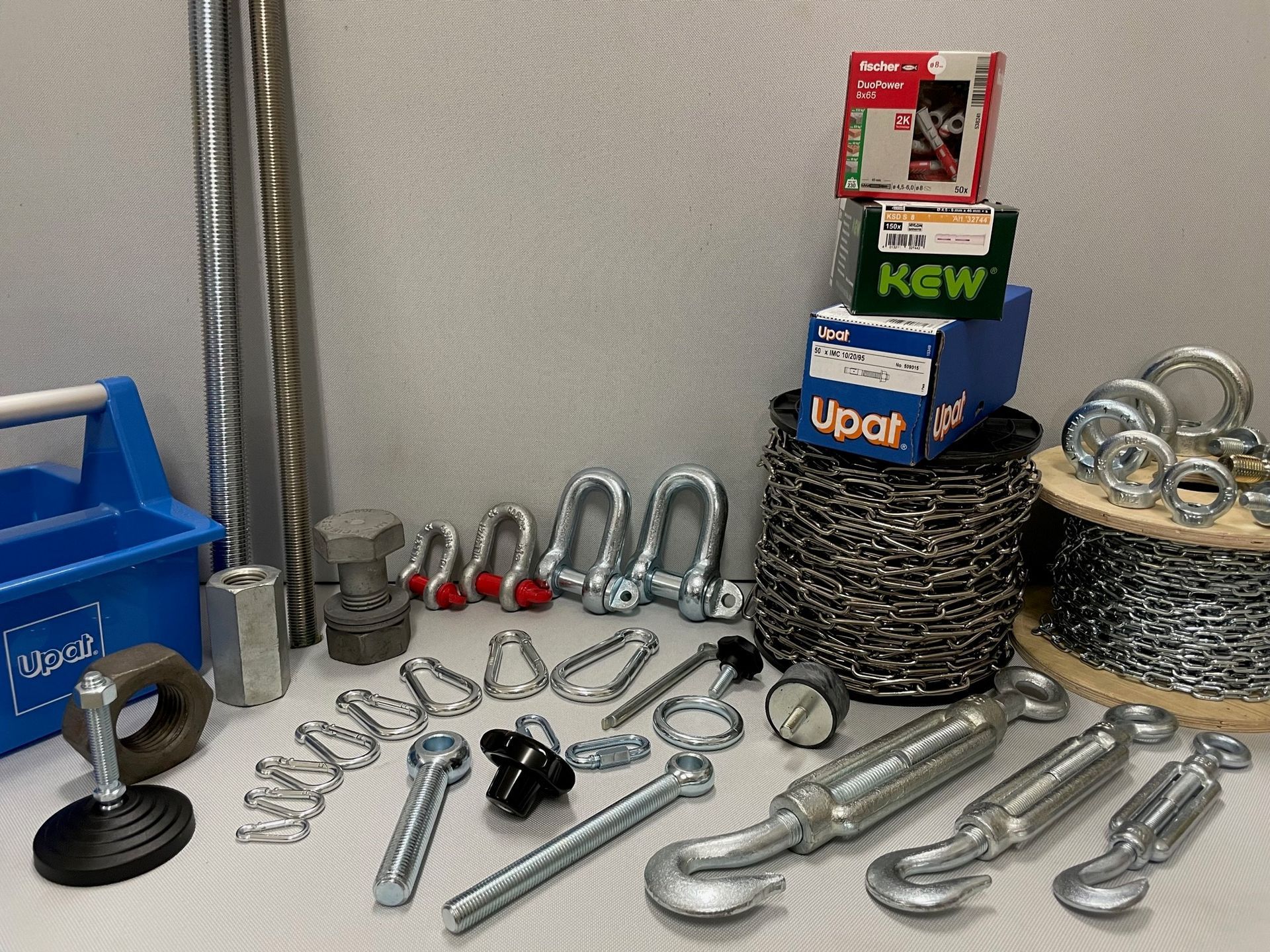 Eisenwaren: Bolzen, Schäkel, Haken, Draht und ein Werkzeugkasten auf weißem Hintergrund.