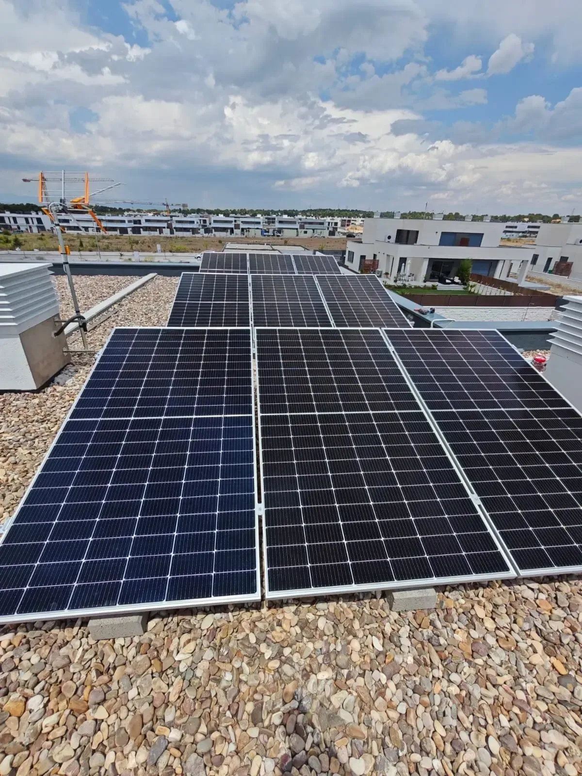 Paneles solares en un tejado bajo un cielo nublado.