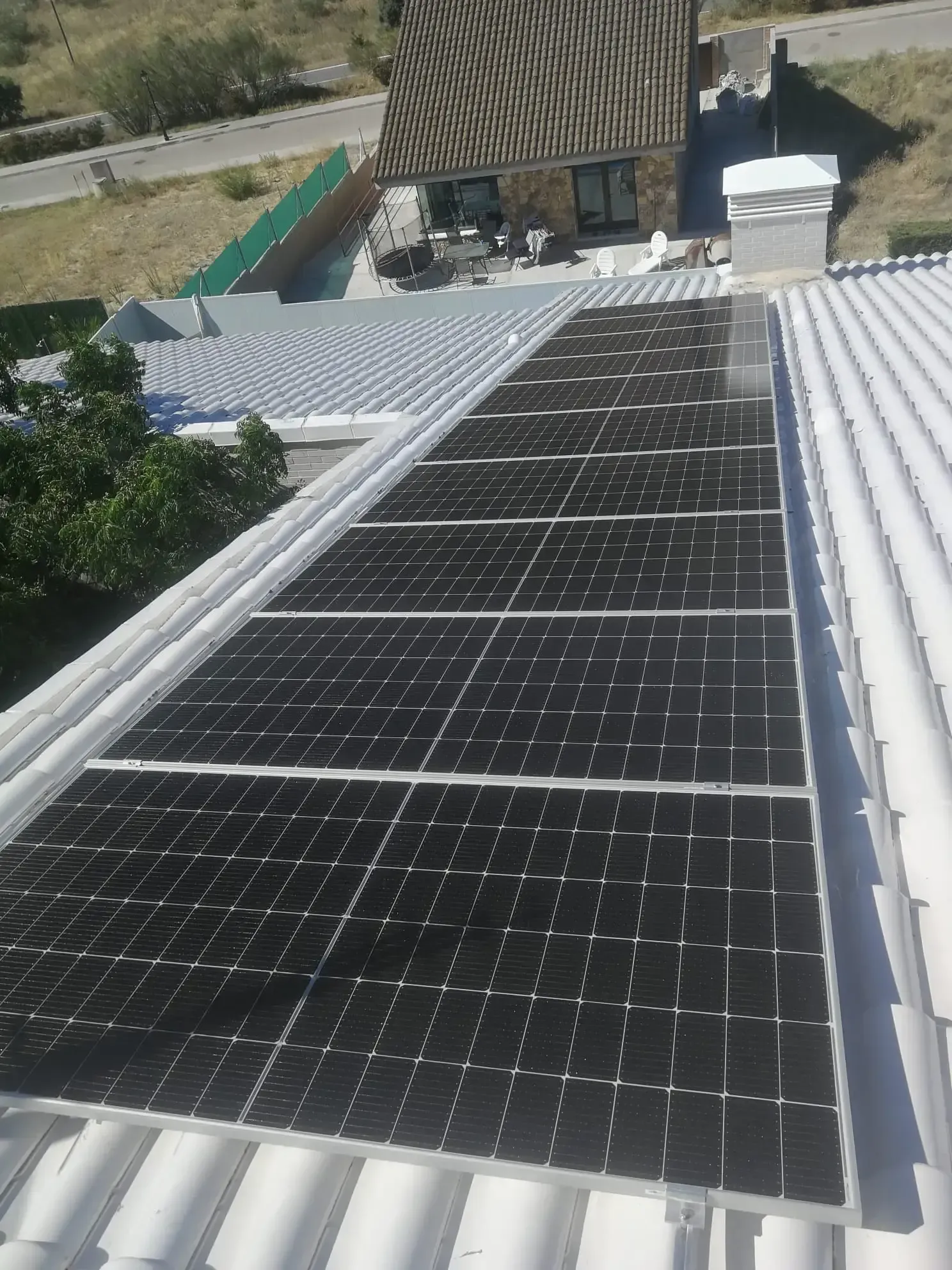 Paneles solares instalados en un techo de chapa ondulada bajo la luz del sol.