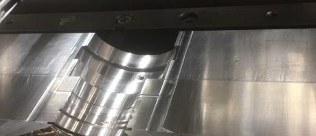 Gros plan sur une pièce métallique brillante d'une machine à l'intérieur d'un boîtier industriel.