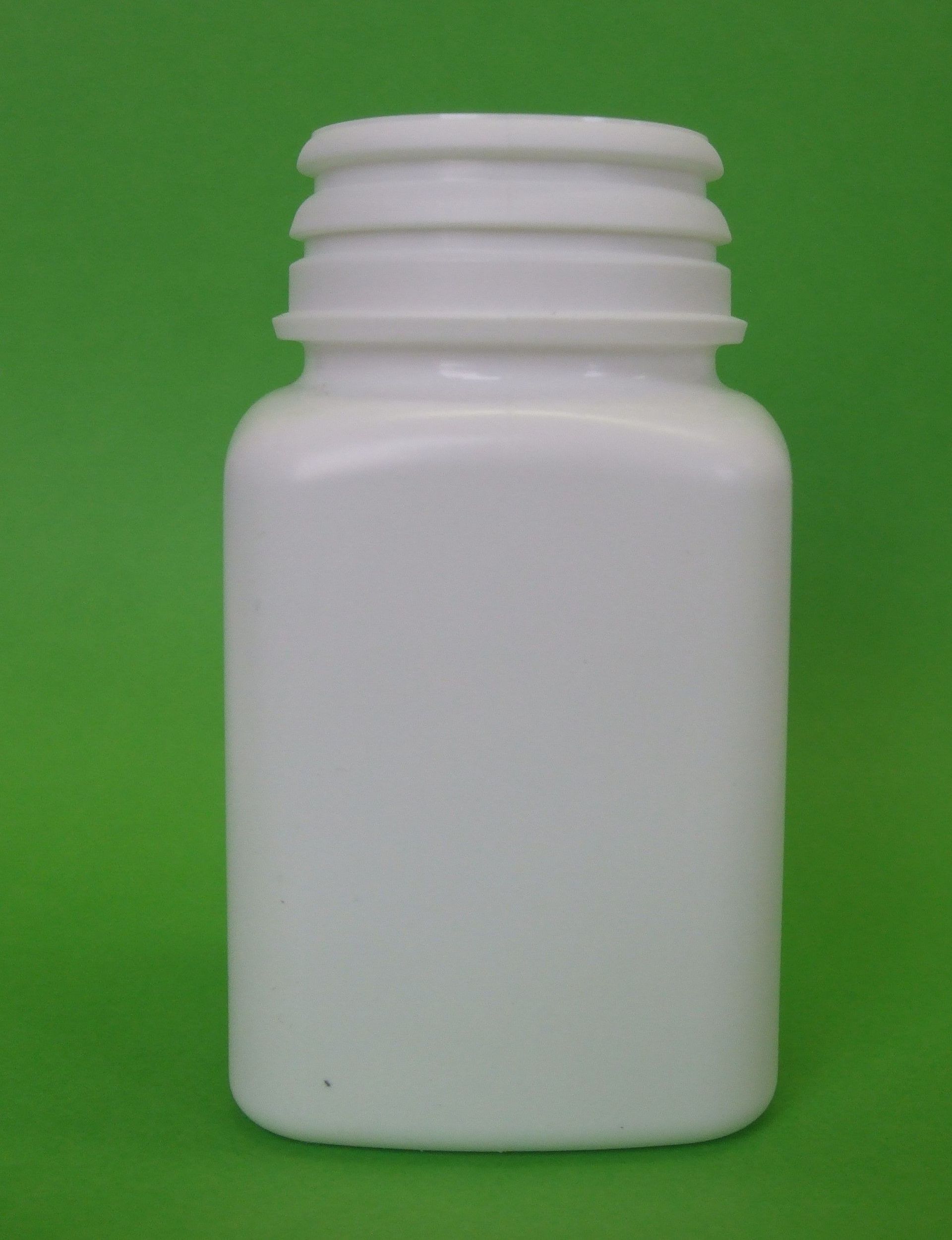 Flacon de pilules en plastique blanc sur fond vert