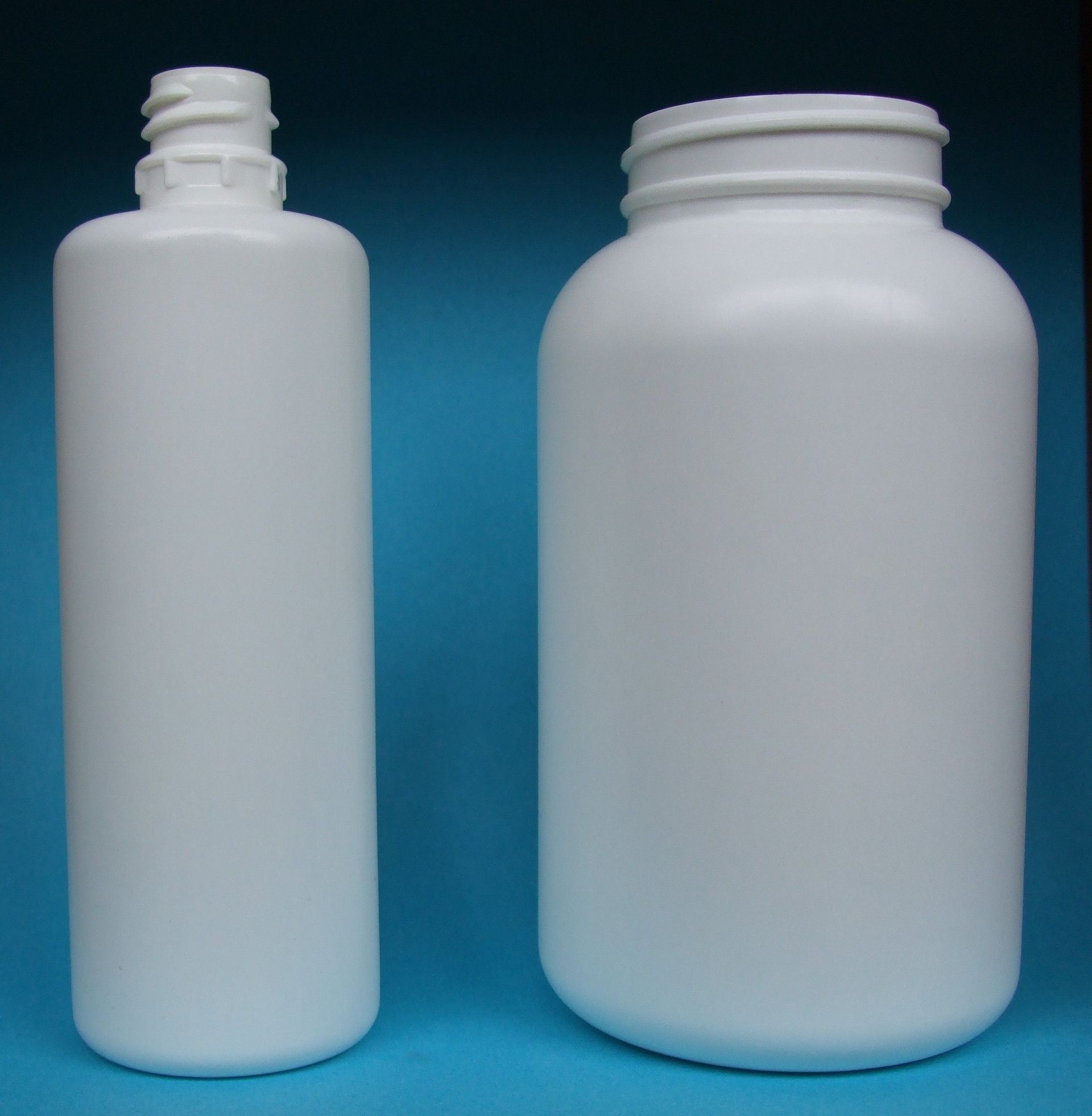 Deux bouteilles en plastique blanc sur fond bleu, l'une haute et étroite, l'autre courte et large.